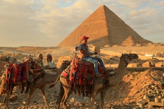 1月24日，商販騎駱駝離開埃及吉薩金字塔景區(qū)。新華社記者 隋先凱 攝