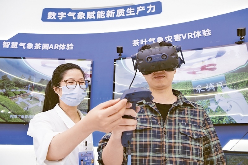 2024年5月23日，第七屆數(shù)字中國建設(shè)峰會現(xiàn)場體驗(yàn)區(qū)在福州海峽國際會展中心向?qū)I(yè)觀眾開放。本次現(xiàn)場體驗(yàn)區(qū)圍繞本屆峰會主題“釋放數(shù)據(jù)要素價(jià)值，發(fā)展新質(zhì)生產(chǎn)力”，設(shè)置“數(shù)字惠民”、“數(shù)字能力”、“數(shù)字基礎(chǔ)”、“數(shù)字生態(tài)”、“數(shù)字賦能”五大板塊。圖為一名觀眾（右）在數(shù)字氣象賦能新質(zhì)生產(chǎn)力展臺上進(jìn)行體驗(yàn)。 新華社記者 魏培全/攝