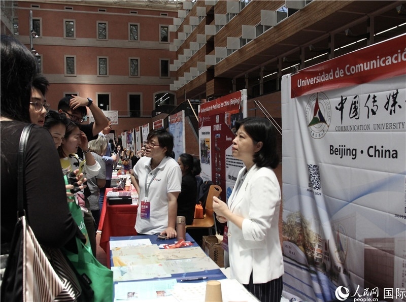 旅西華人華僑在展臺(tái)前咨詢。人民網(wǎng)記者 許海林?jǐn)z