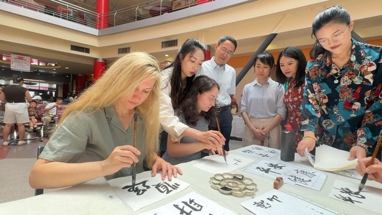 羅馬尼亞友人在活動現(xiàn)場學寫漢字。中國駐羅馬尼亞大使館領(lǐng)僑處供圖