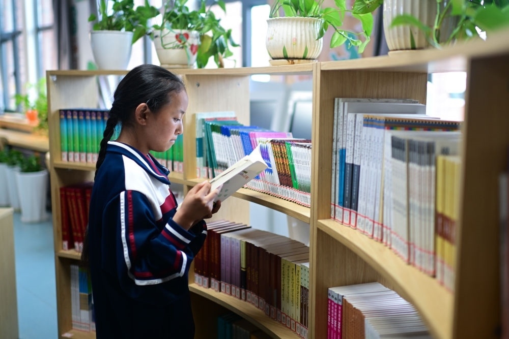 6月18日，果洛西寧民族中學(xué)學(xué)生尼東拉毛在圖書室看書。