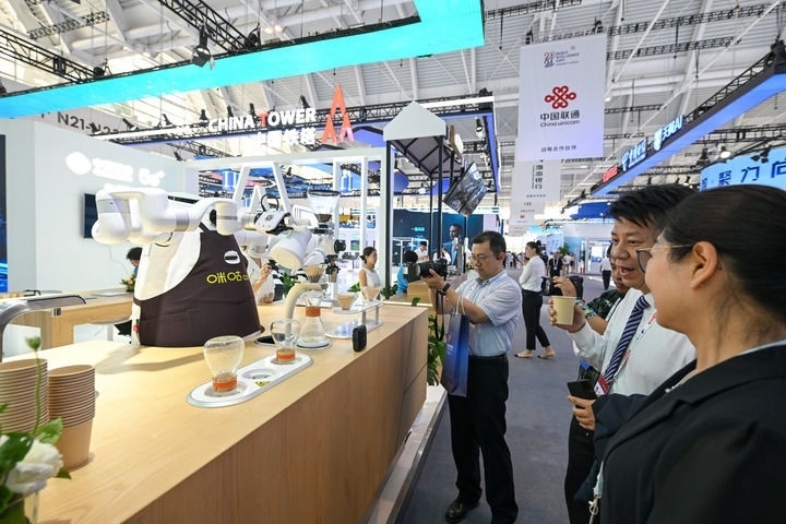 6月20日，與會者品嘗機器人沖調(diào)出的咖啡。新華社記者 孫凡越 攝