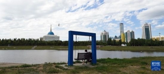 6月30日，一名女子在哈薩克斯坦首都阿斯塔納伊希姆河畔休息。新華社記者 王建華 攝