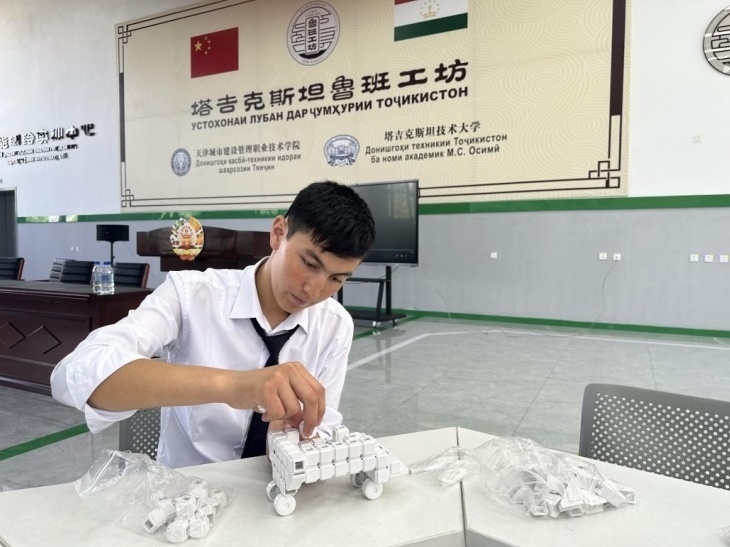 在塔吉克斯坦魯班工坊內(nèi)，學員正在操作能力源創(chuàng)新套件。本報記者 屈佩 攝