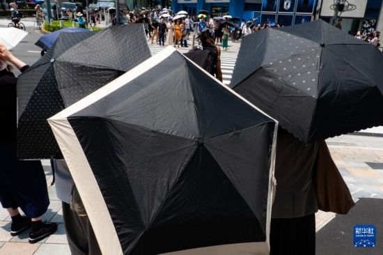 7月4日，人們?cè)谌毡緰|京原宿的街道上等待紅綠燈。新華社記者 張笑宇 攝