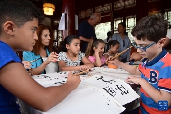 7月4日，在馬耳他桑塔露琪亞市的中國古典園林“靜園”，人們體驗中國書法。新華社發(fā)（喬納森·博格 攝）