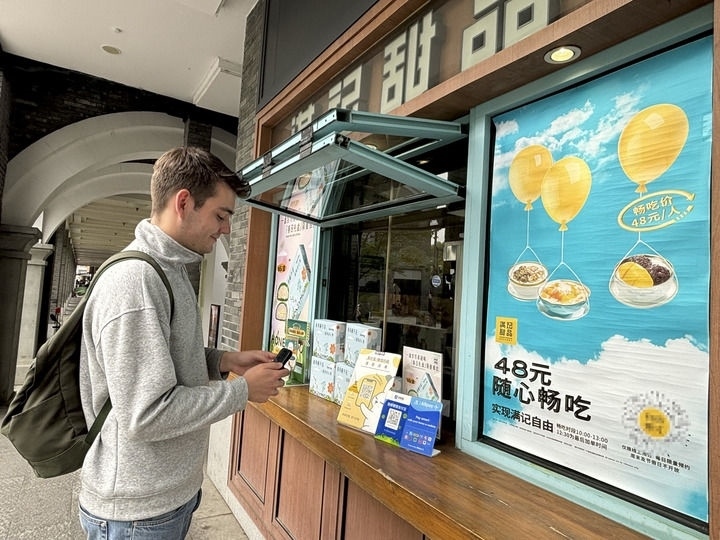 來自德國的留學生理查德在杭州西湖邊一家商鋪使用支付寶掃碼支付（2024年4月11日攝）。新華社發(fā)