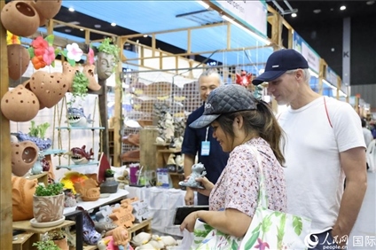 游客在蘭納博覽會(huì)特色展位上選購(gòu)工藝品。人民網(wǎng)記者楊一攝