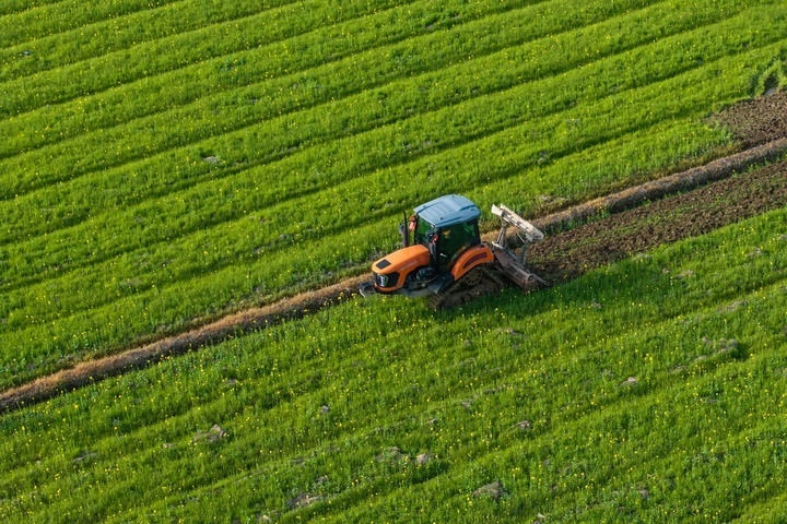 2024年3月19日，在湖南省常德市鼎城區(qū)謝家鋪鎮(zhèn)港中坪村，村民駕駛農(nóng)機(jī)翻耕田地（無(wú)人機(jī)照片）。新華社記者 陳思汗 攝