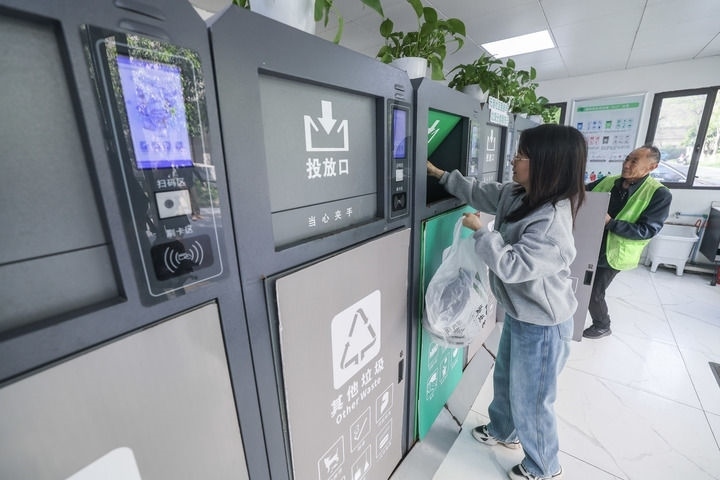 2024年4月10日，在浙江省湖州市吳興區(qū)飛英街道新華府小區(qū)內(nèi)，居民在垃圾分類(lèi)智能系統(tǒng)的指導(dǎo)下進(jìn)行垃圾分類(lèi)投放，居民的投放情況將實(shí)時(shí)匯總到智慧服務(wù)平臺(tái)，會(huì)有相應(yīng)的積分獎(jiǎng)勵(lì)。新華社記者 徐昱 攝