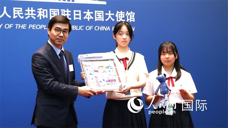 日本小大使向中國駐日本大使館臨時代辦施泳贈送當?shù)靥厣Y品。人民網(wǎng) 許可攝