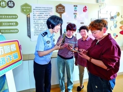 浙江湖州民警指導居民加入湖州“e企安”微信群，實時接收反詐信息。新華社發(fā)