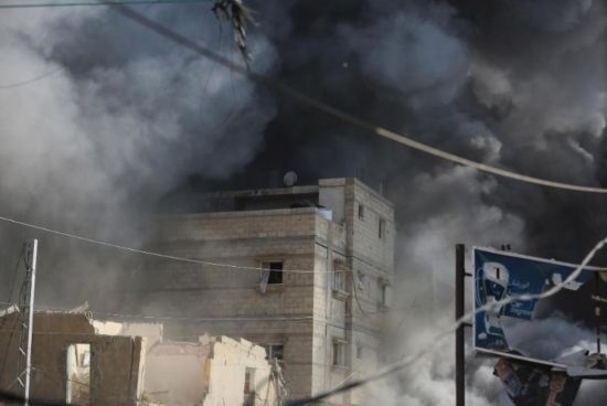 7月21日，在加沙地帶中部的努賽賴特難民營(yíng)，遭以軍空襲的建筑冒出滾滾濃煙。新華社發(fā)（馬爾萬(wàn)·達(dá)烏德攝）