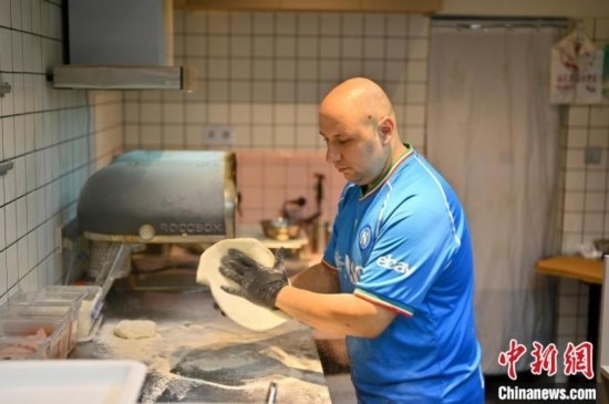 近日，韋榮耀在自家披薩小店內(nèi)忙活。俞靖 攝