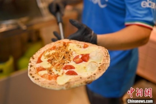 近日，韋榮耀展示他制作的“老友味”披薩。 俞靖 攝