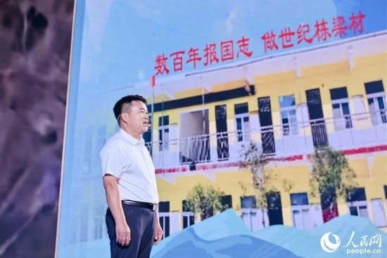 張玉滾分享用一根扁擔(dān)送孩子們走出大山的故事。人民網(wǎng)攝