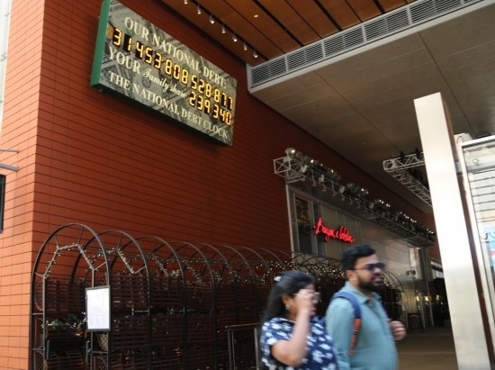 2023年5月29日，人們經(jīng)過(guò)美國(guó)紐約曼哈頓的“國(guó)債鐘”?！皣?guó)債鐘”是一個(gè)大型計(jì)數(shù)器，它實(shí)時(shí)更新美國(guó)的公共債務(wù)總額，并顯示出每個(gè)美國(guó)家庭所要負(fù)擔(dān)的數(shù)額。 新華社記者劉亞南攝