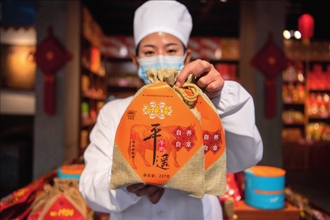 在位于山西省晉中市平遙縣的平遙古城南大街的一家平遙牛肉店內(nèi)，工作人員展示一款牛肉產(chǎn)品（資料照片）楊晨光攝 / 本刊