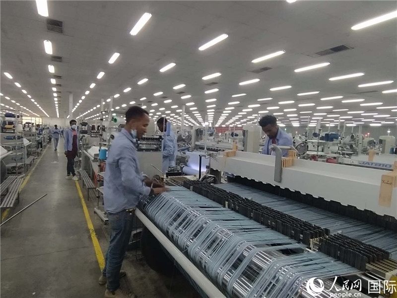 無(wú)錫金茂埃塞面料廠車(chē)間內(nèi)，當(dāng)?shù)毓と苏谝唤z不茍地作業(yè)。人民網(wǎng)記者 黃培昭攝