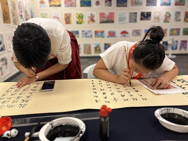 參加本次展覽的青少年在現(xiàn)場進(jìn)行書法創(chuàng)作。主辦方供圖