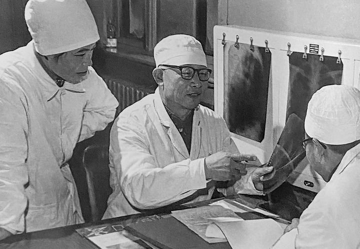 1980年1月16日，中日友好醫(yī)院首任院長辛育齡（中）在內(nèi)蒙古結(jié)核病院與胸外科醫(yī)師討論病例（翻拍照片）。 新華社發(fā)