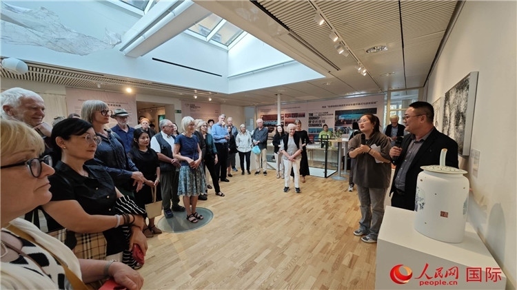 參展人、景德鎮(zhèn)陶瓷大學(xué)美術(shù)學(xué)院副院長(zhǎng)邵長(zhǎng)宗（右一）向來(lái)賓介紹參展作品。人民網(wǎng)記者 殷淼攝