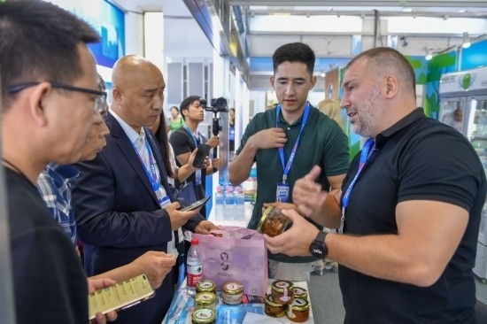 2023年8月23日，在第十四屆中國(guó)—東北亞博覽會(huì)東北亞商品館，俄羅斯參展商向參觀者介紹商品。