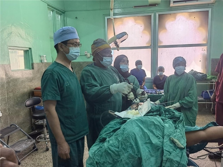 隊(duì)長(zhǎng)蔣國(guó)慶（左一）關(guān)注當(dāng)?shù)蒯t(yī)生手術(shù)情況。中國(guó)援桑醫(yī)療隊(duì)供圖