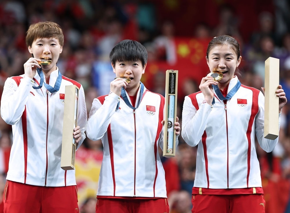 冠軍中國隊選手王曼昱、孫穎莎、陳夢（從左至右）在巴黎奧運會乒乓球女子團體頒獎儀式上（2024年8月10日攝）。新華社記者 王東震 攝