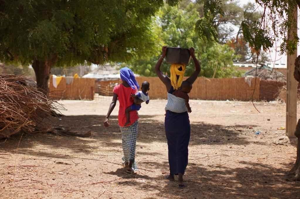 2023年3月20日，在塞內(nèi)加爾久爾貝勒區(qū)的泰內(nèi)富勒村，村民將取到的水運(yùn)回家。新華社記者 王子正 攝