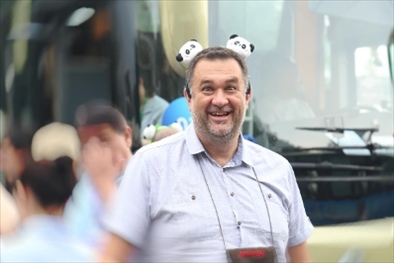 參訪熊貓谷前，塞爾維亞“一帶一路”研究所所長博揚·拉利奇戴上熊貓頭飾。（李佩藺 攝）