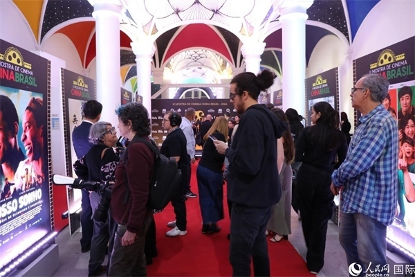 為期4天的第三屆中國(guó)－巴西電影展期間，來(lái)自中巴兩國(guó)的14部參展影片受到巴西電影愛(ài)好者和社會(huì)各界人士好評(píng)，圖為當(dāng)?shù)赜^眾在影展舉辦地巴西里約熱內(nèi)盧勞拉—阿爾維姆文化之家的迎賓廳欣賞參展電影海報(bào)。 人民網(wǎng)記者 陳一鳴攝