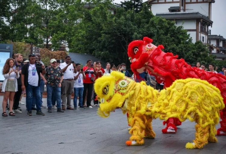 2024“一帶一路”媒體合作論壇聯合采訪調研行成員在樂山蘇稽古鎮(zhèn)觀看非遺舞獅表演。本報記者 伊霄攝