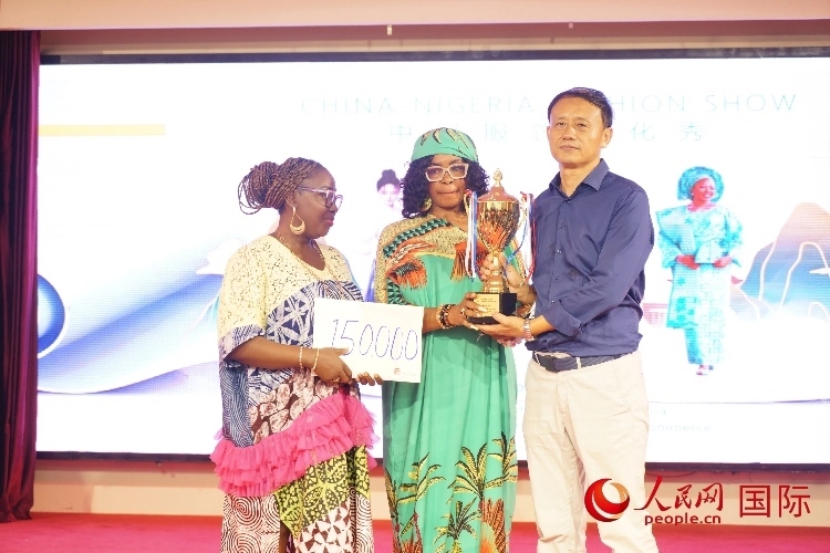 中國(guó)駐尼日利亞使館文化參贊兼中國(guó)文化中心主任李旭大（右）為最佳表現(xiàn)獎(jiǎng)?lì)C獎(jiǎng)（中）。人民網(wǎng)記者 姜宣攝