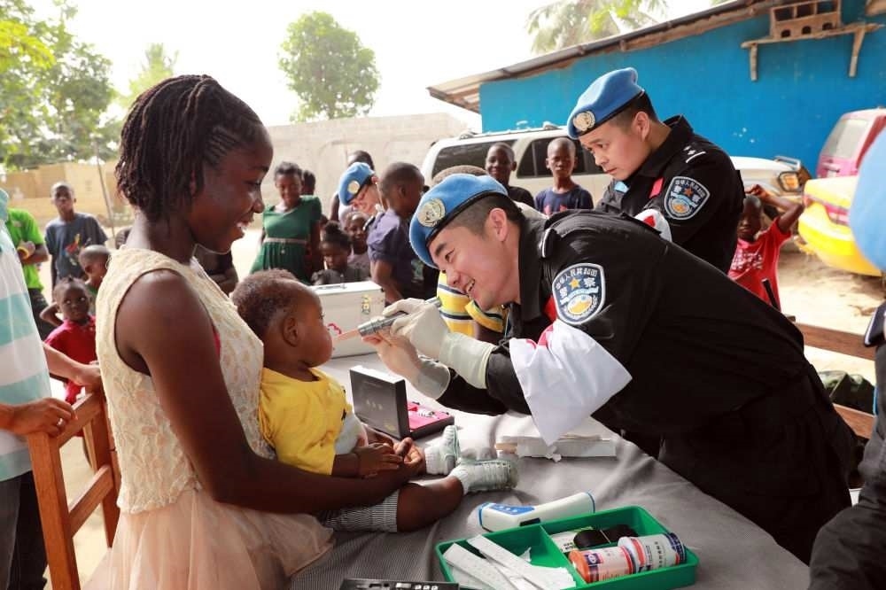 2017年12月28日，在利比里亞蒙羅維亞，中國(guó)維和警察防暴隊(duì)醫(yī)療人員為兒童做口腔檢查。