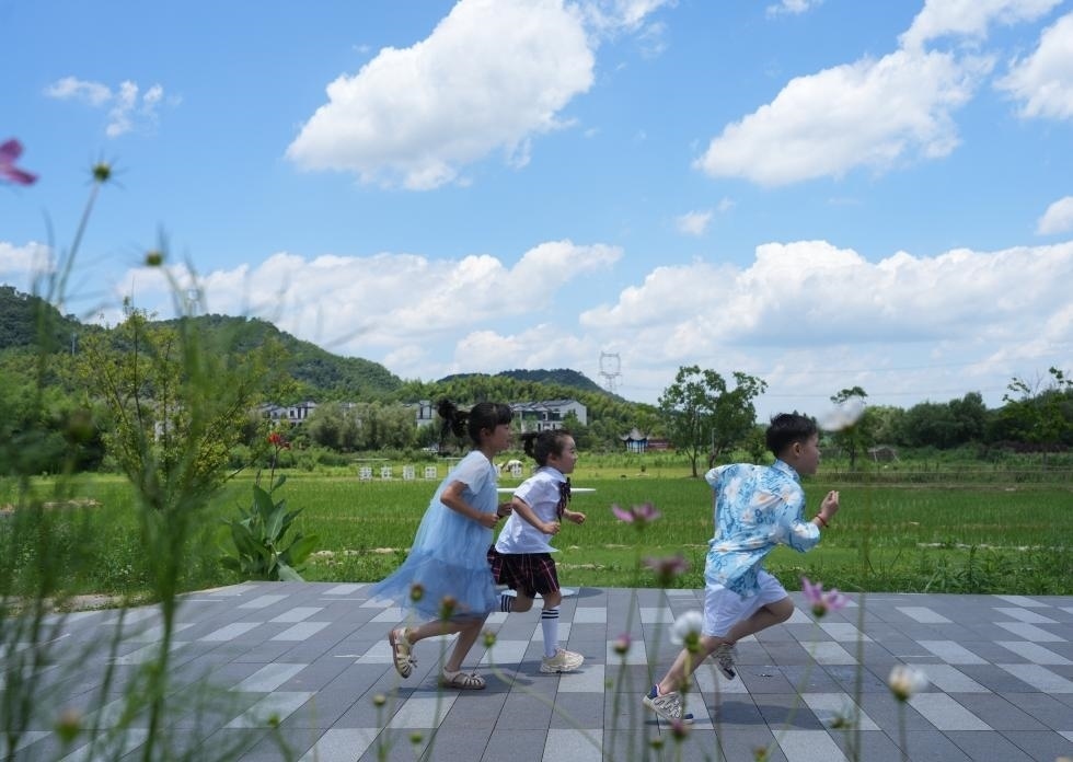 兒童在余姚市梁弄鎮(zhèn)的田野間奔跑（7月3日攝）。新華社記者翁忻旸 攝