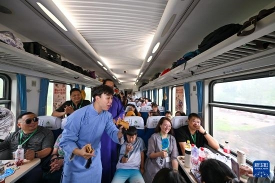 9月7日，相聲演員在S910列車上為旅客表演快板。