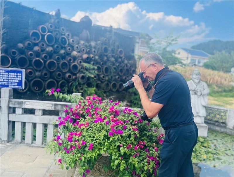 遠(yuǎn)處黔北民居錯(cuò)落有致，近處一只黑色的蝴蝶穿梭于粉紫色三角梅花叢間隙，與俄羅斯“大歐亞”總編輯弗拉基米爾·別列日內(nèi)赫的鏡頭玩起了捉迷藏，“你追我逃，不亦樂(lè)乎”。（張亞欣攝）