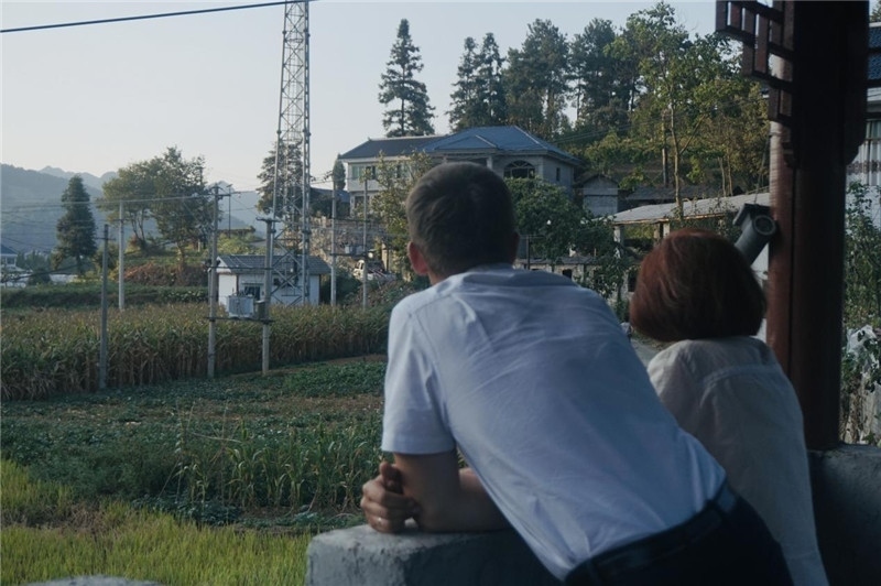 望得見(jiàn)山，看得見(jiàn)水，記得住鄉(xiāng)愁。每個(gè)人心中都有一個(gè)屬于自己的“花茂村”，在這方心田，走遍千山萬(wàn)水，鄉(xiāng)音未改鬢毛衰。吉爾吉斯斯坦《比什凱克晚報(bào)》第一副總編輯妮娜·尼奇博洛娃與《中國(guó)與俄羅斯》雜志社社長(zhǎng)奧列格·別列日內(nèi)赫攝在花茂村民居屋檐下并肩佇立，眺望山水，尋覓鄉(xiāng)愁。（李光裕攝）