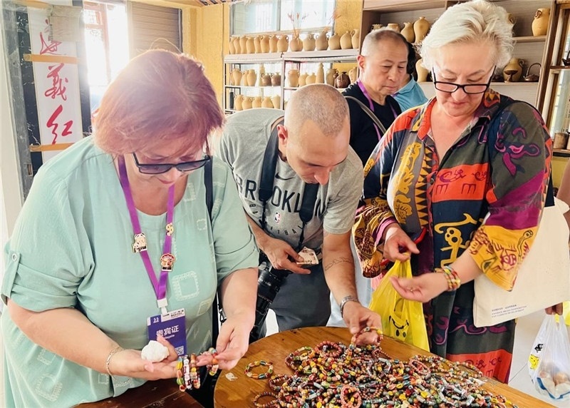 歐亞媒體考察團(tuán)成員在母氏陶藝館內(nèi)挑花了眼，色彩絢麗、質(zhì)地均勻的陶藝手串讓他們愛(ài)不釋手?！斑@里的東西都太實(shí)惠了！”塔吉克斯坦《索格特真理報(bào)》政論部主任娜塔利婭·多羅費(fèi)耶娃說(shuō)?；宓奶厣a(chǎn)品物美價(jià)廉，讓考察團(tuán)成員為家人好友買到了心儀的禮物，也為此次以四川成都為起點(diǎn)，路經(jīng)南充、廣安至貴州遵義的考察行程畫上了圓滿句號(hào)。（張亞欣攝）