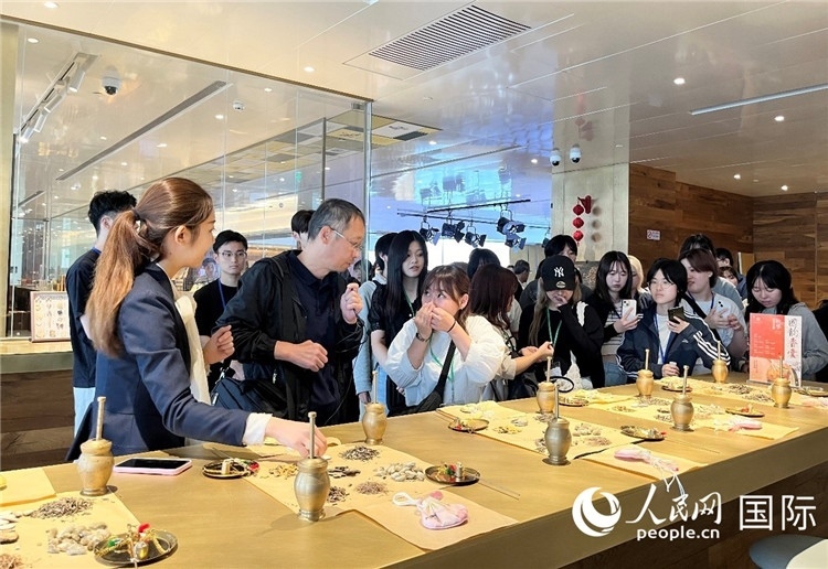 1. 日中友好協(xié)會青年代表團一行學習中醫(yī)香囊制作工序。（人民網記者陳思 攝）