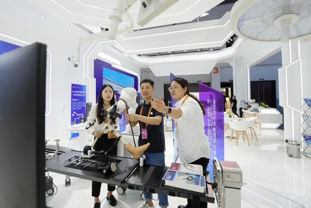 9月11日，一位媒體記者（中）在2024年服貿(mào)會(huì)國(guó)家會(huì)議中心會(huì)場(chǎng)體驗(yàn)北京納通科技集團(tuán)有限公司的膝關(guān)節(jié)置換手術(shù)機(jī)器人。新華社記者鞠煥宗 攝