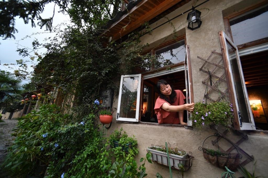 8月29日，在福建省屏南縣熙嶺鄉(xiāng)，龍?zhí)洞濉靶麓迕瘛泵泛暝诖蚶碜约航?jīng)營(yíng)的民宿外墻裝飾花盆。新華社記者姜克紅 攝