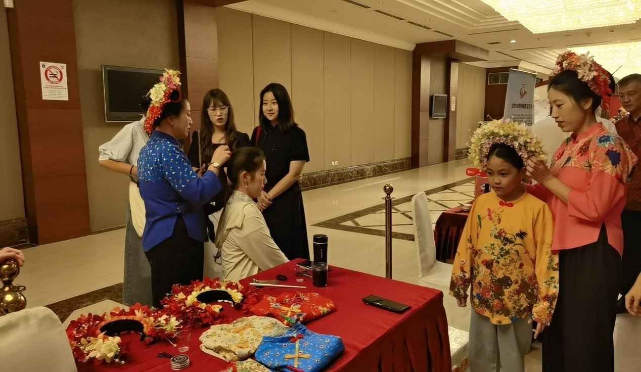 阿拉扎大學孔子學院志愿者老師向傳承人學習簪花圍。阿拉扎大學孔子學院供圖