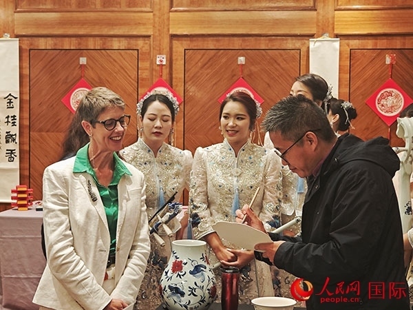 現(xiàn)場(chǎng)的非遺傳承人為英國觀眾展示畫技。人民網(wǎng)記者 邢雪攝