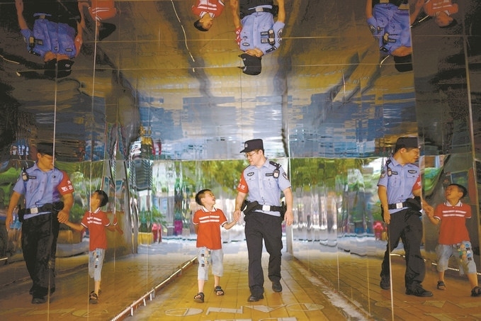 ?7月16日，重慶市公安局江北區(qū)分局一名民警在巡邏途中遇到一個(gè)獨(dú)自玩耍的小男孩，民警將其送回家。王洪平攝