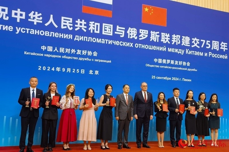 楊萬明會長和莫爾古洛夫大使為10位中俄青年友好微視頻創(chuàng)意大賽獲獎代表頒獎。人民網(wǎng)記者 李明琪攝