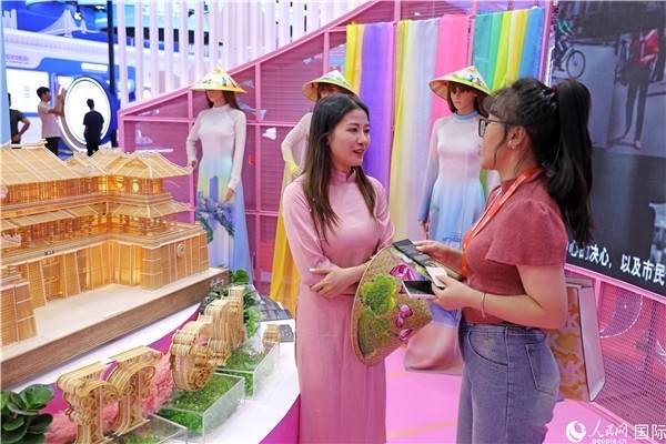 參觀者在東博會越南展區(qū)同工作人員咨詢交談。人民網(wǎng)記者 趙益普攝