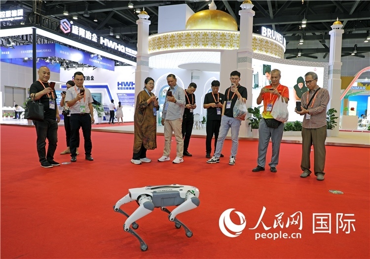東博會(huì)上，觀眾正在參觀一只機(jī)器狗。綠色能源、新能源汽車、綠色農(nóng)產(chǎn)品等成為本屆東博會(huì)觀眾關(guān)注的焦點(diǎn)。人民網(wǎng)記者 趙益普攝