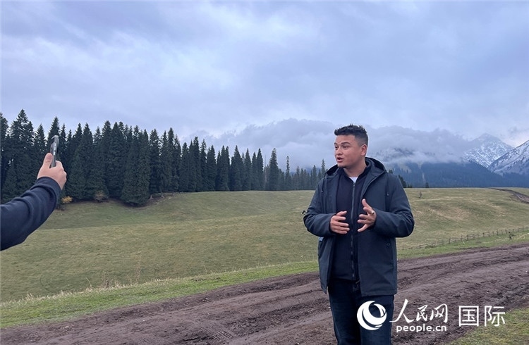 在庫爾德寧，吾買爾江被雪山美景震撼，即興錄制了短視頻作品。人民網(wǎng)記者曾書柔攝